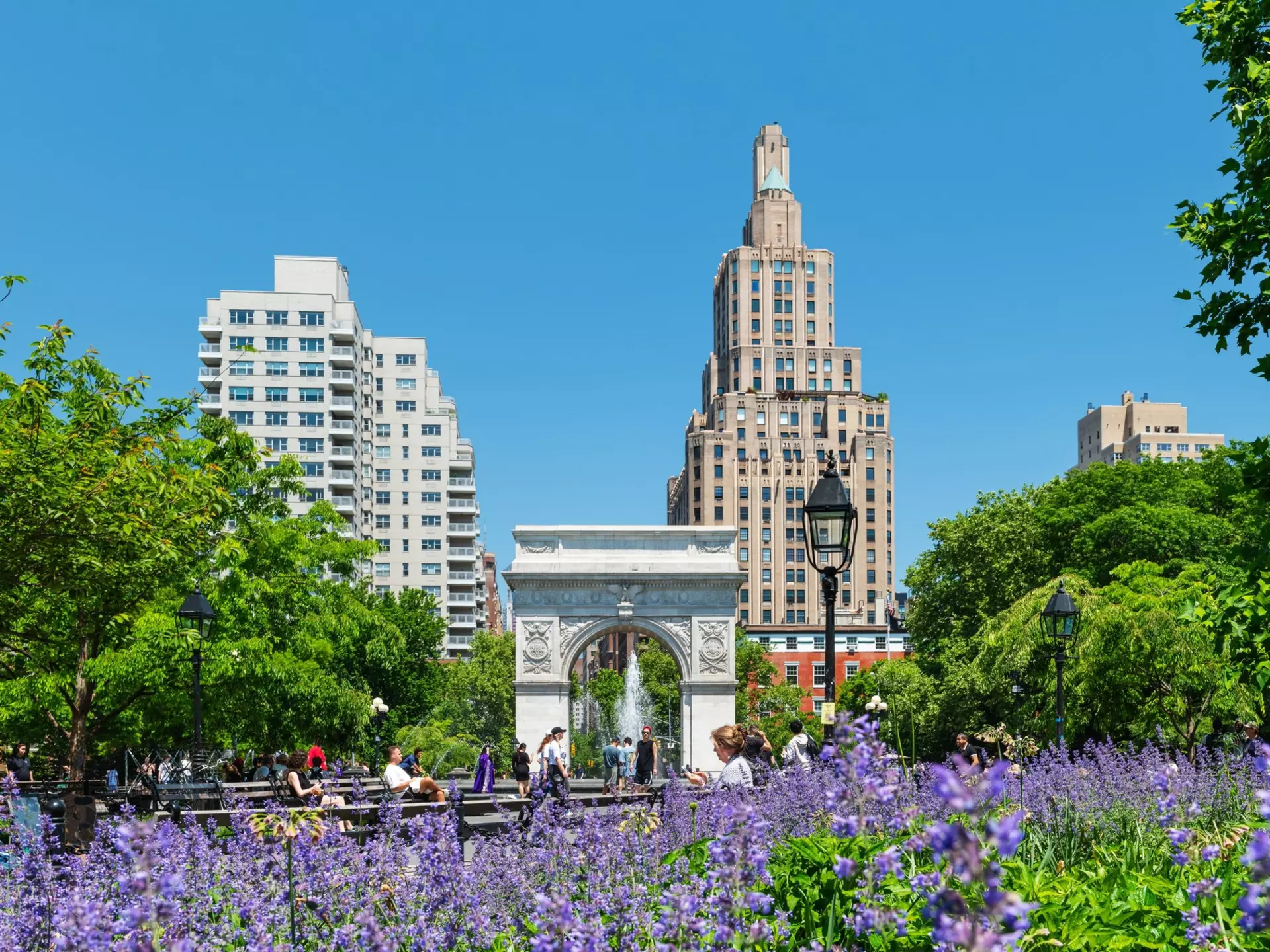 Washington Square Park in Manhattan with the iconic landmark arch and visitors enjoying a sunny spring morning
