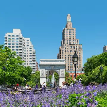 Washington Square Park in Manhattan with the iconic landmark arch and visitors enjoying a sunny spring morning