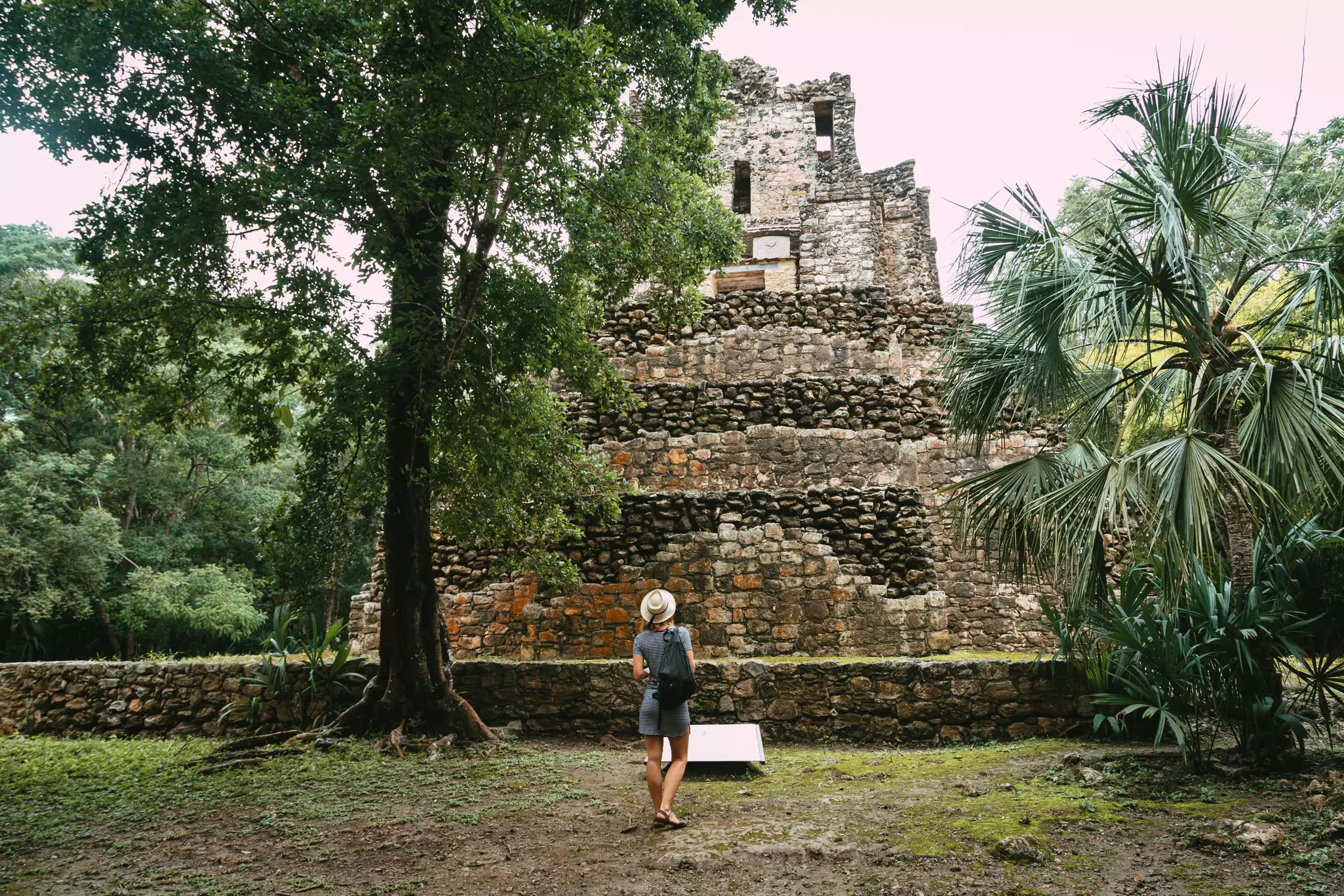 Tourist near the ancient Mayan pyramid. Lost city in the jungle. Ancient Mayan Pyramid at the Muyil site in Quintana Roo.