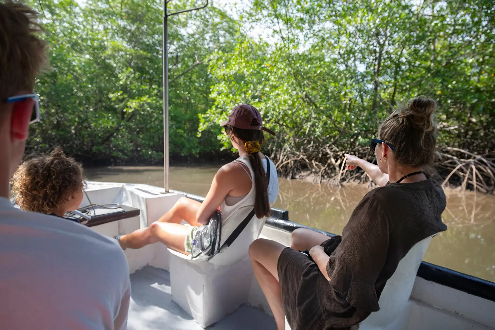View from behind of a family on a wildlife estuary boat tour in Costa Rica.