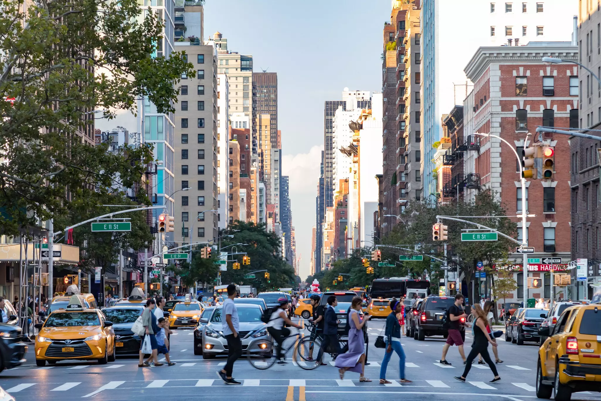 People crossing a busy street at rush hour