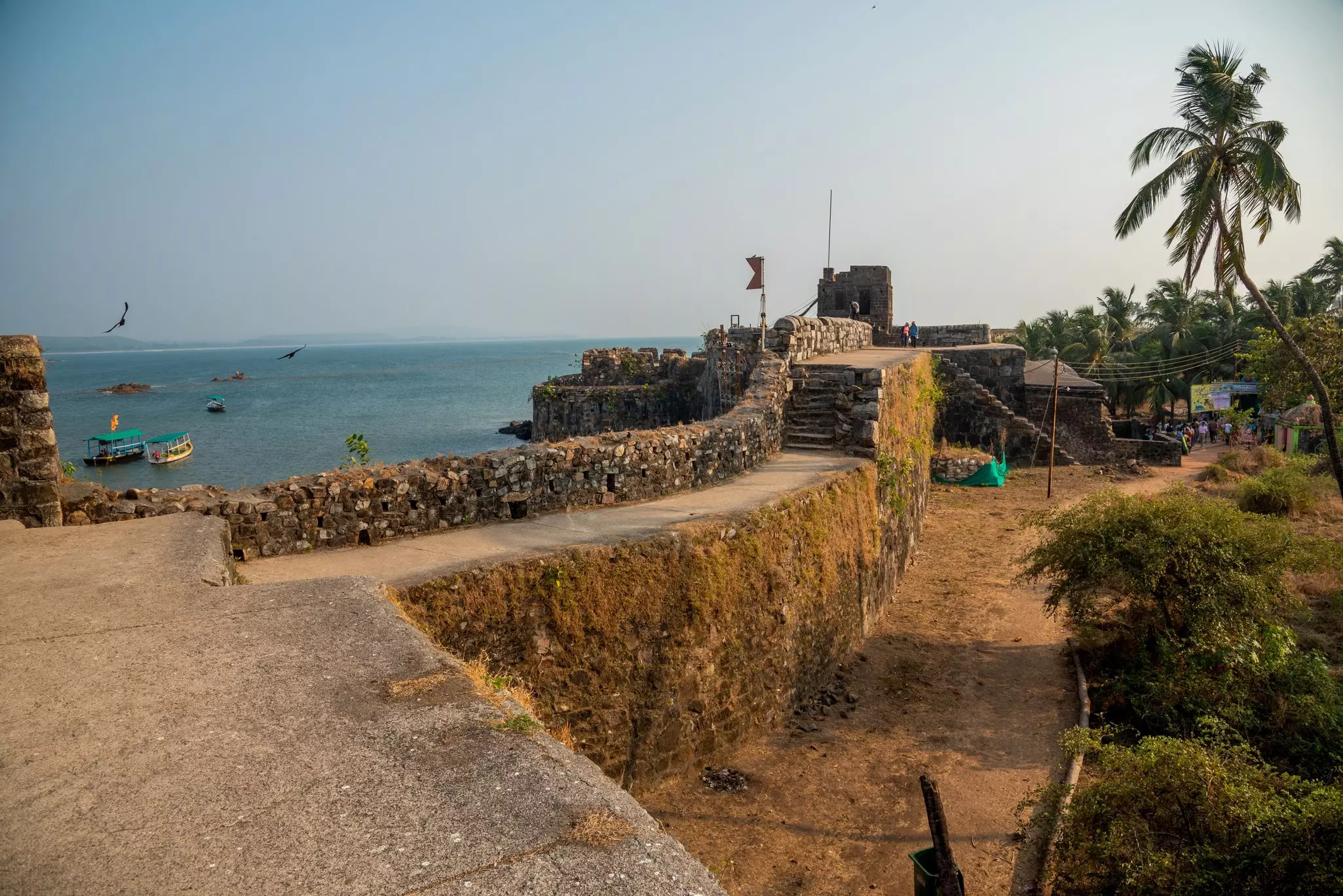 Stone walls leading to a brick fort overlooking the sea