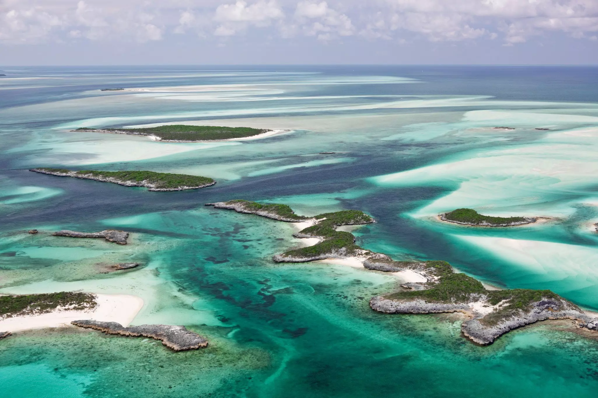 Aerial view of the islands, beautiful sandy bottom and green water contours of the Exumas in the Bahamas.