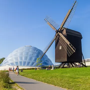 Historic windmill and modern greenhouse in the botanical garden of Aarhus, Denmark.