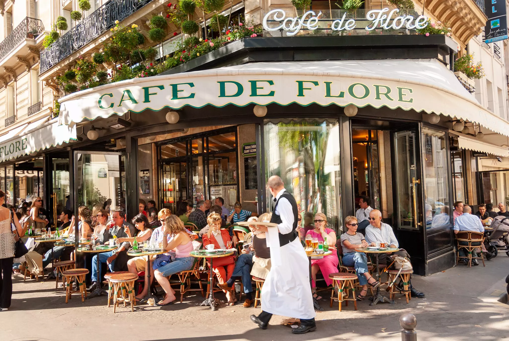 People sitting outside Cafe de Flore in the 6th arrondissement of Paris.