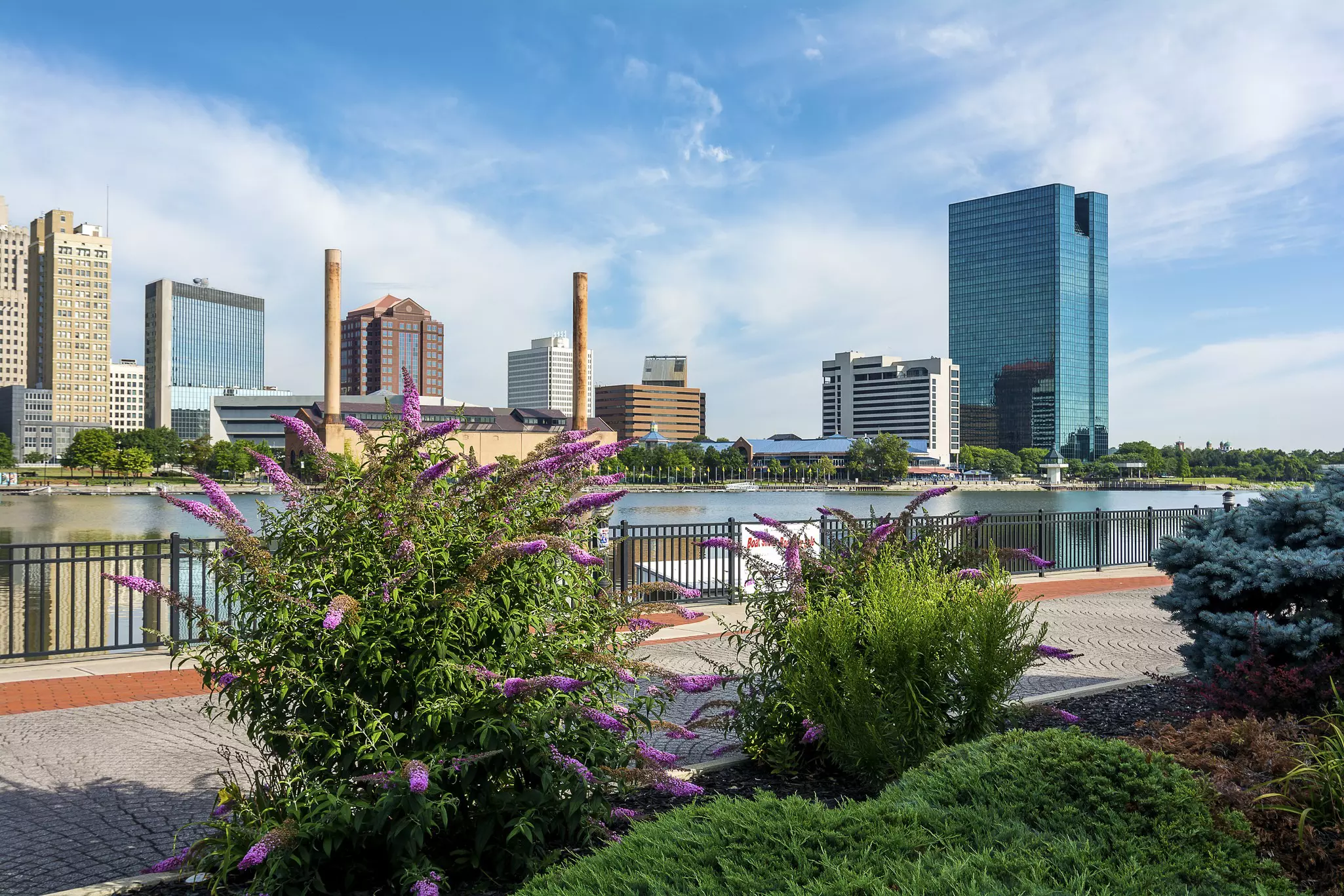 A panoramic view of downtown Toledo Ohio's skyline from across the Maumee river at the Docks. A beautiful blue sky with white clouds for a backdrop.