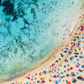 Aerial of a crowded sandy beach with colourful umbrellas, sun bathers and swimmers during summer.
1139897468
above, aerial, background, bay, beach, beautiful, blue, coast, coastline, colorful, day, drone, europe, exotic, holidays, island, journey, lagoon, landscape, leisure, lie, marina, nature, ocean, paradise, people, relax, resort, sand, sandy, sea, seascape, seashore, shore, spain, summer, sunny, swim, top, transparent, travel, tropical, vacation, view, water, wave, parasol, umbrella