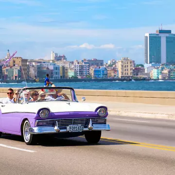 A classic car on the seafront in Havana