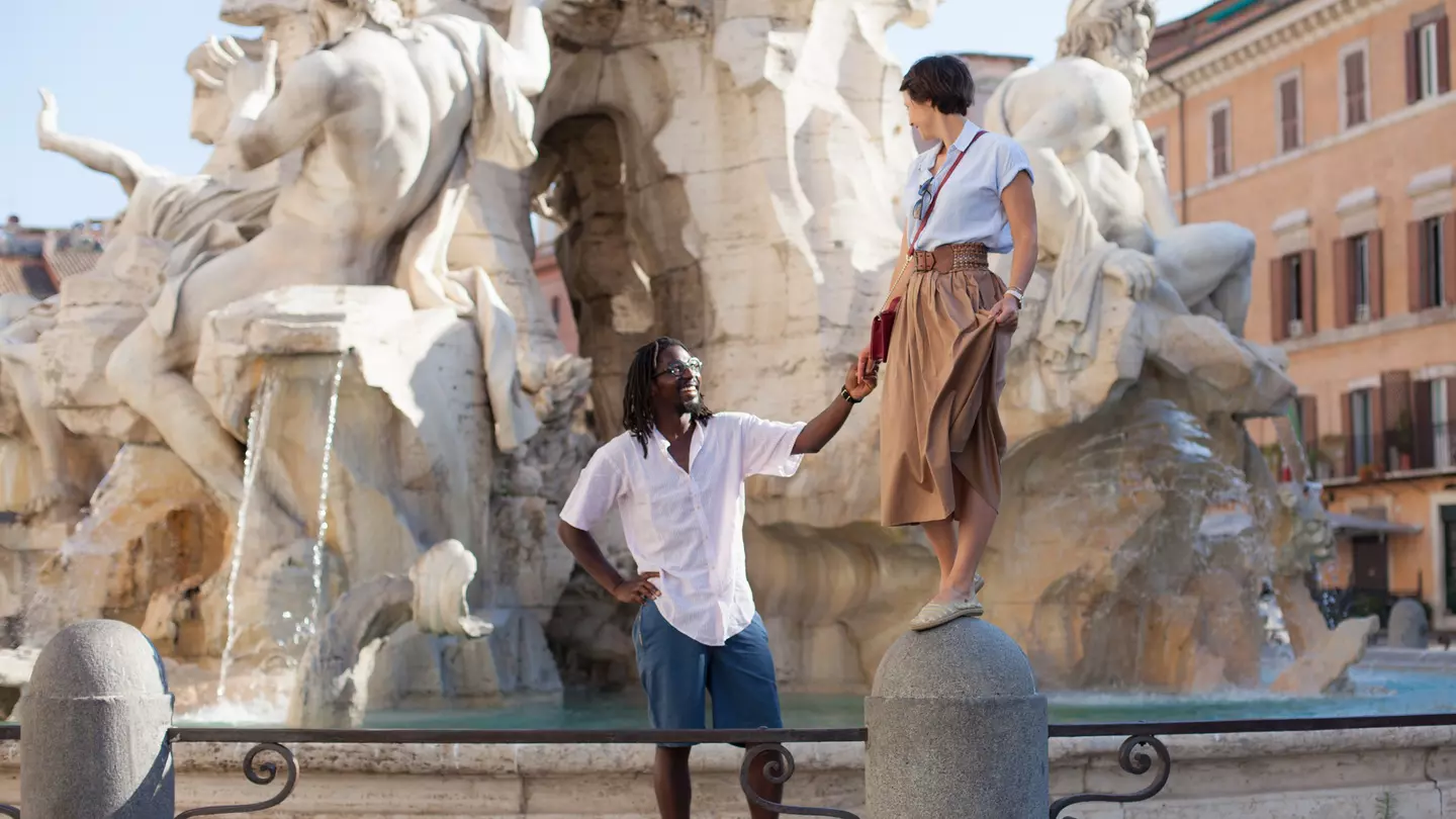 Beautiful biracial couple at Bernini fountain in Piazza Navona, Rome, Italy