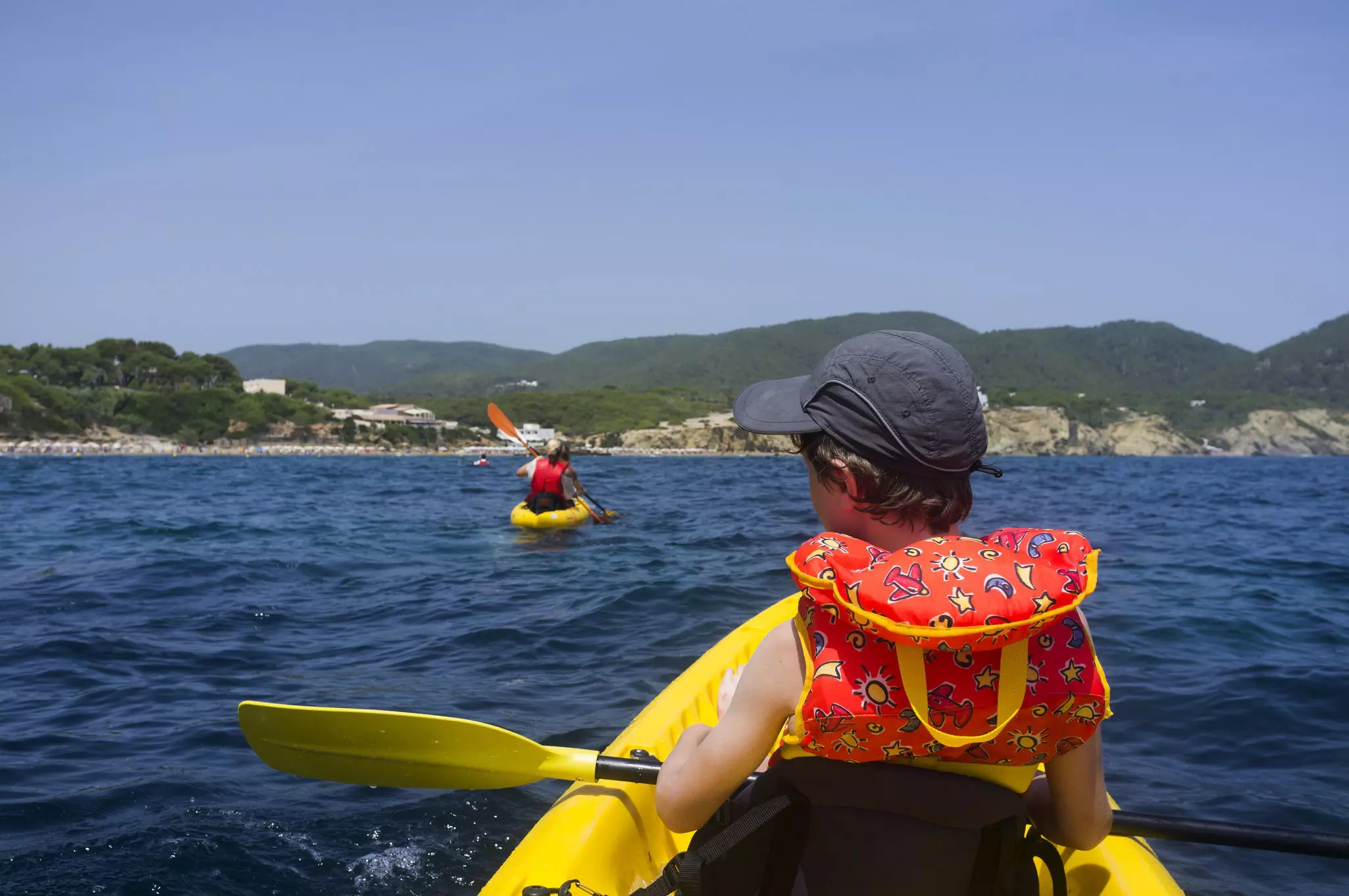 A young boy in a kayak in blue water