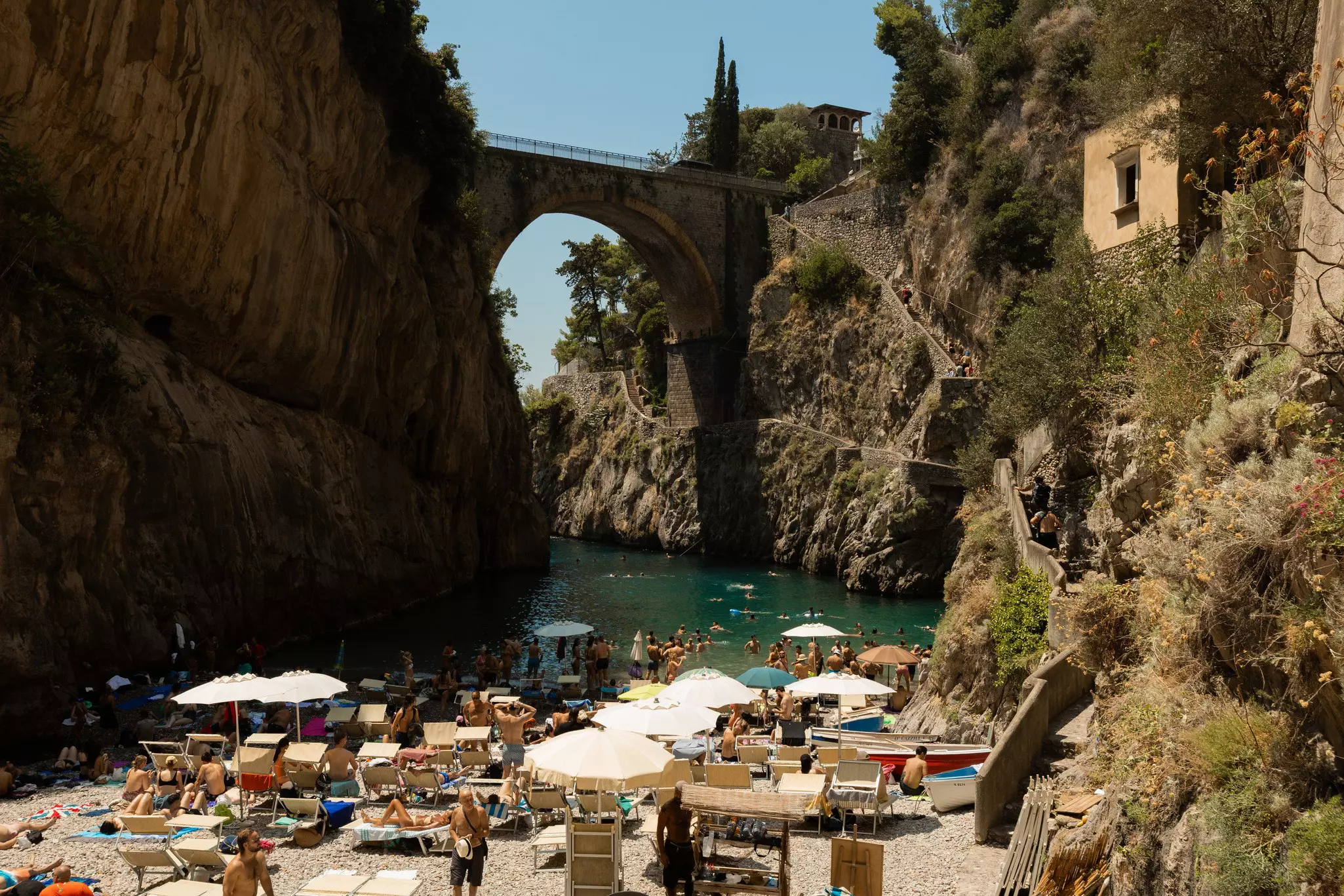 Group of crowds with umbrellas on the beach in the Amalfi Coast.