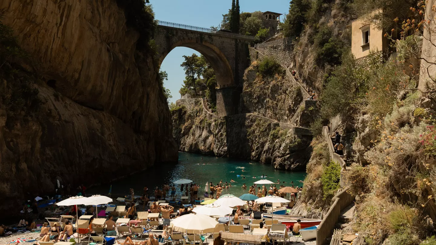 Group of crowds with umbrellas on the beach in the Amalfi Coast.
