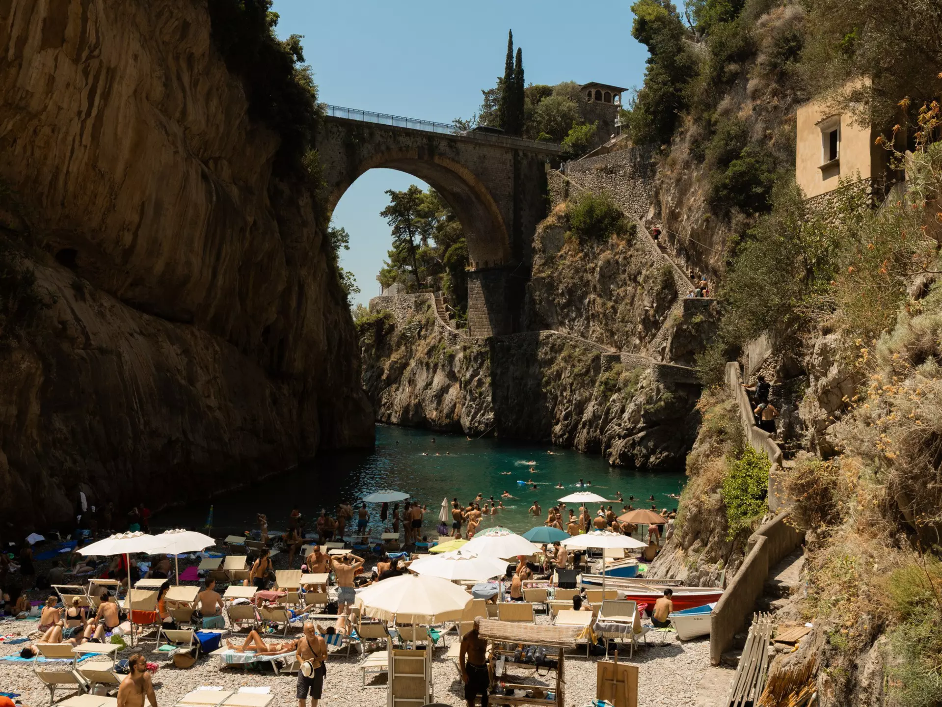 Group of crowds with umbrellas on the beach in the Amalfi Coast.