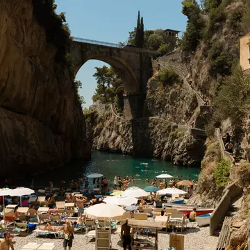 Group of crowds with umbrellas on the beach in the Amalfi Coast.