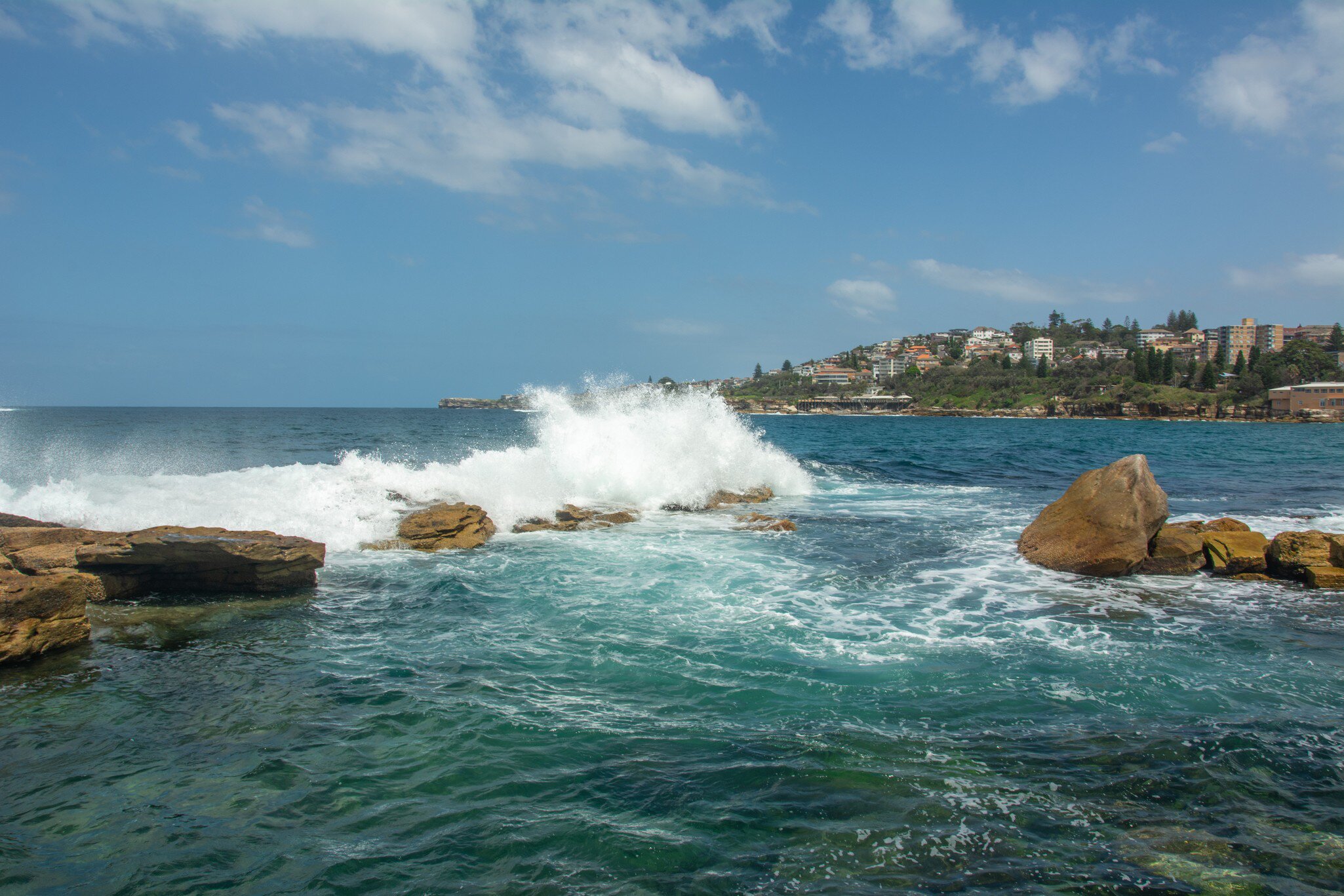 Waves crashing at Giles Baths from Dolphin Point at the northern end of the Coogee Beach on Thompsons Bay near Sydney, New South Wales, Australia.