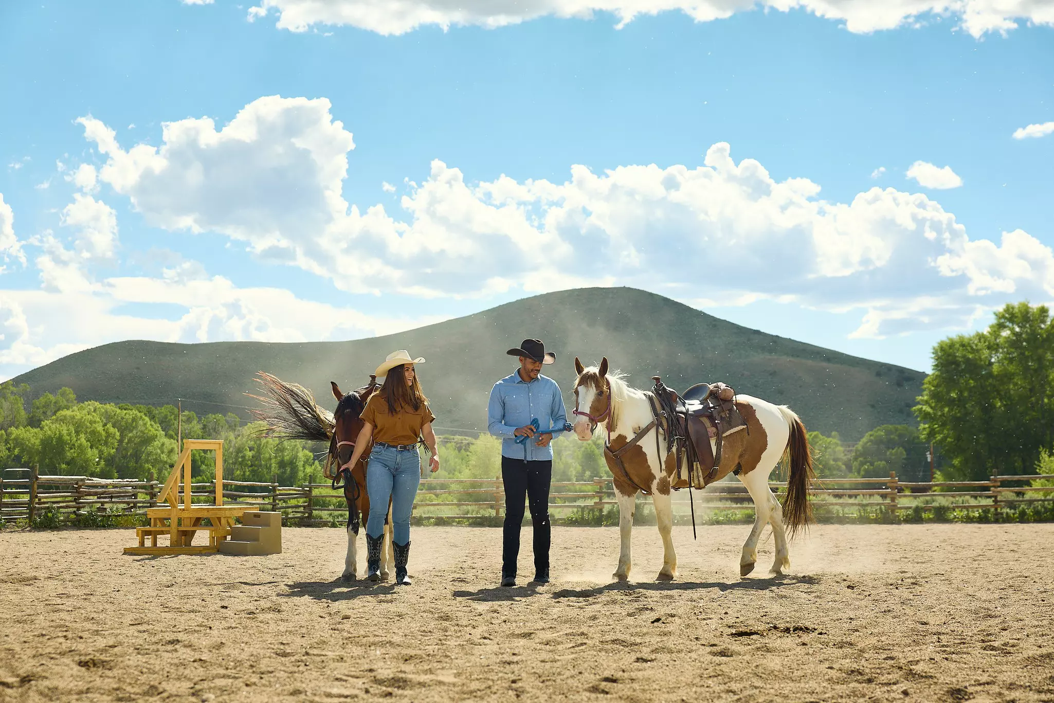 A man and woman lead horses at a dude ranch in Grand County. Colorado, USA.