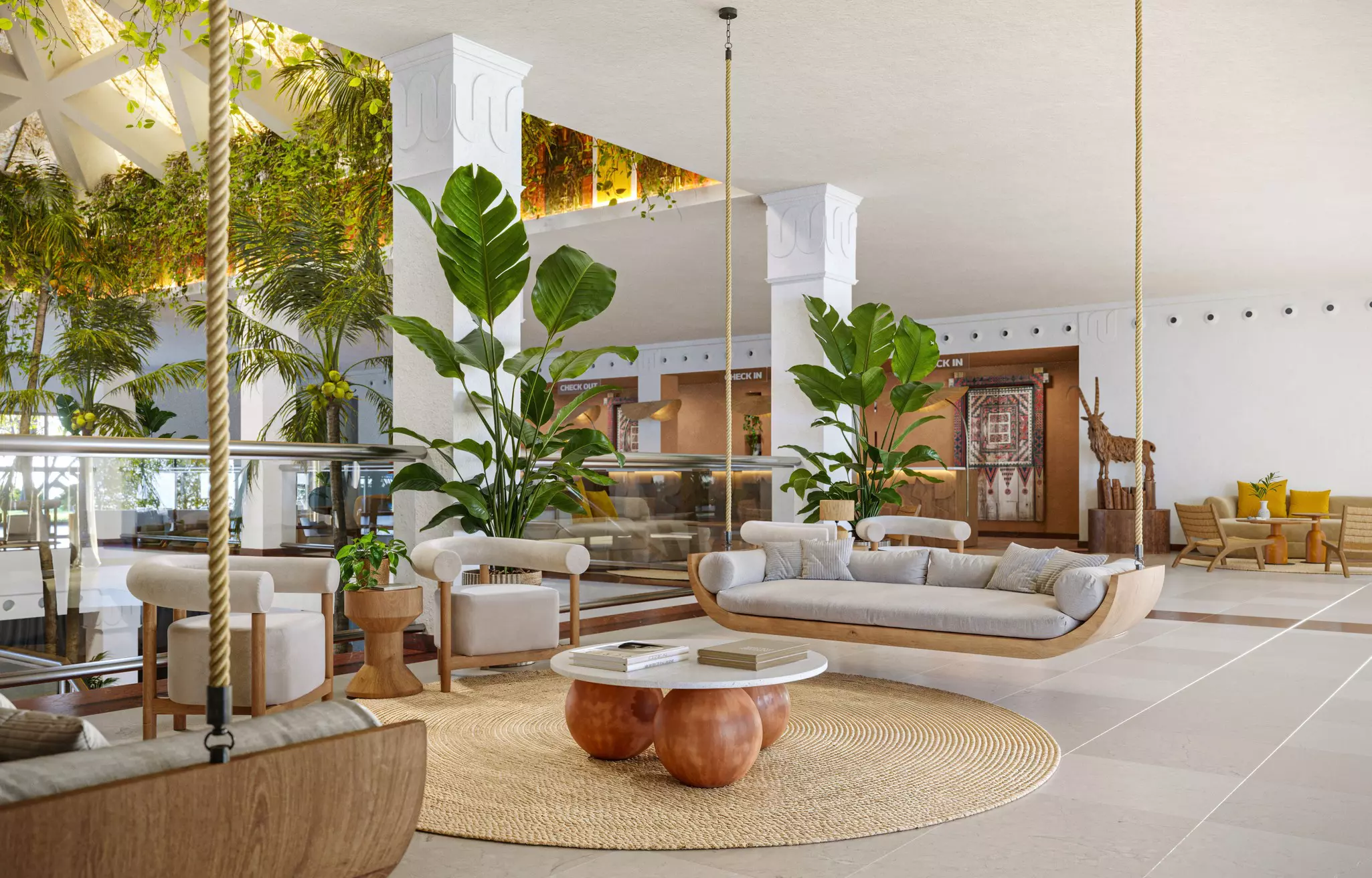The relaxed lobby of the Iberostar Selection hotel in Fuerteventura with rattan furniture, greenery and neutral tiled floors.