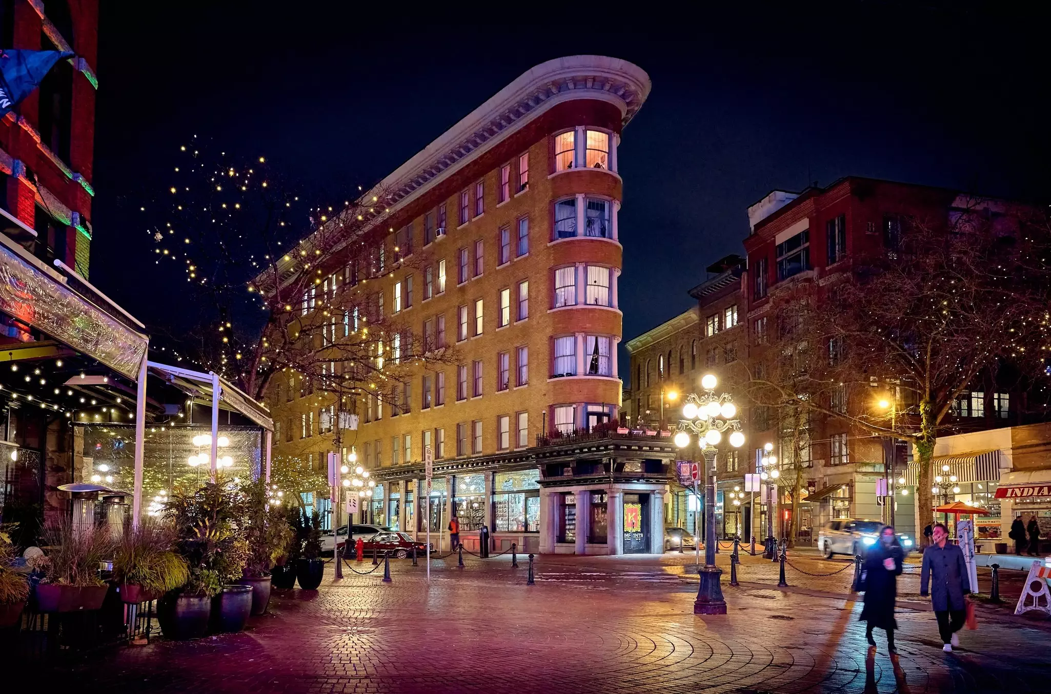 A city square in Vancouver, Canada, at night, with lights in the trees.