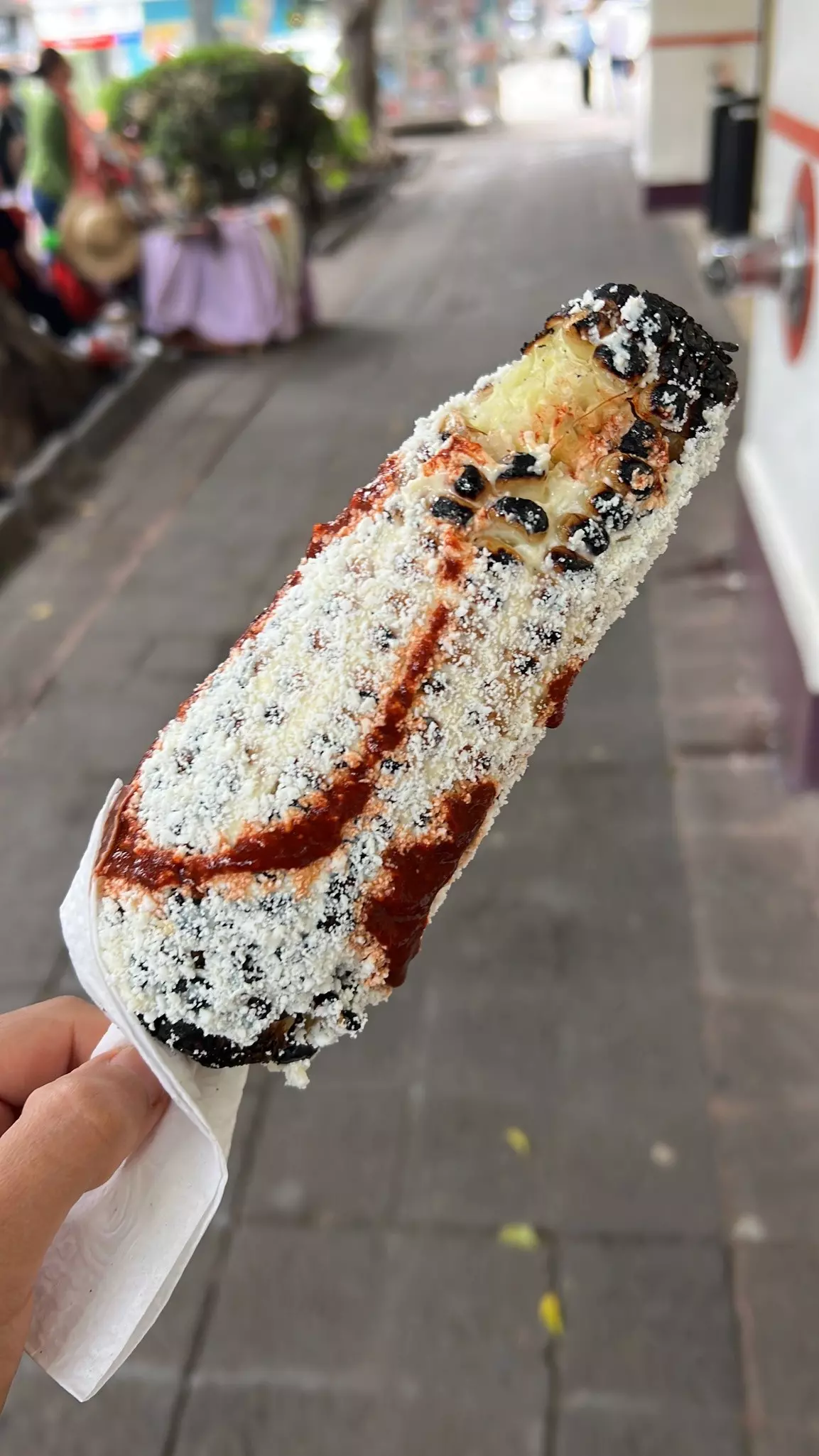 An elote held in hand