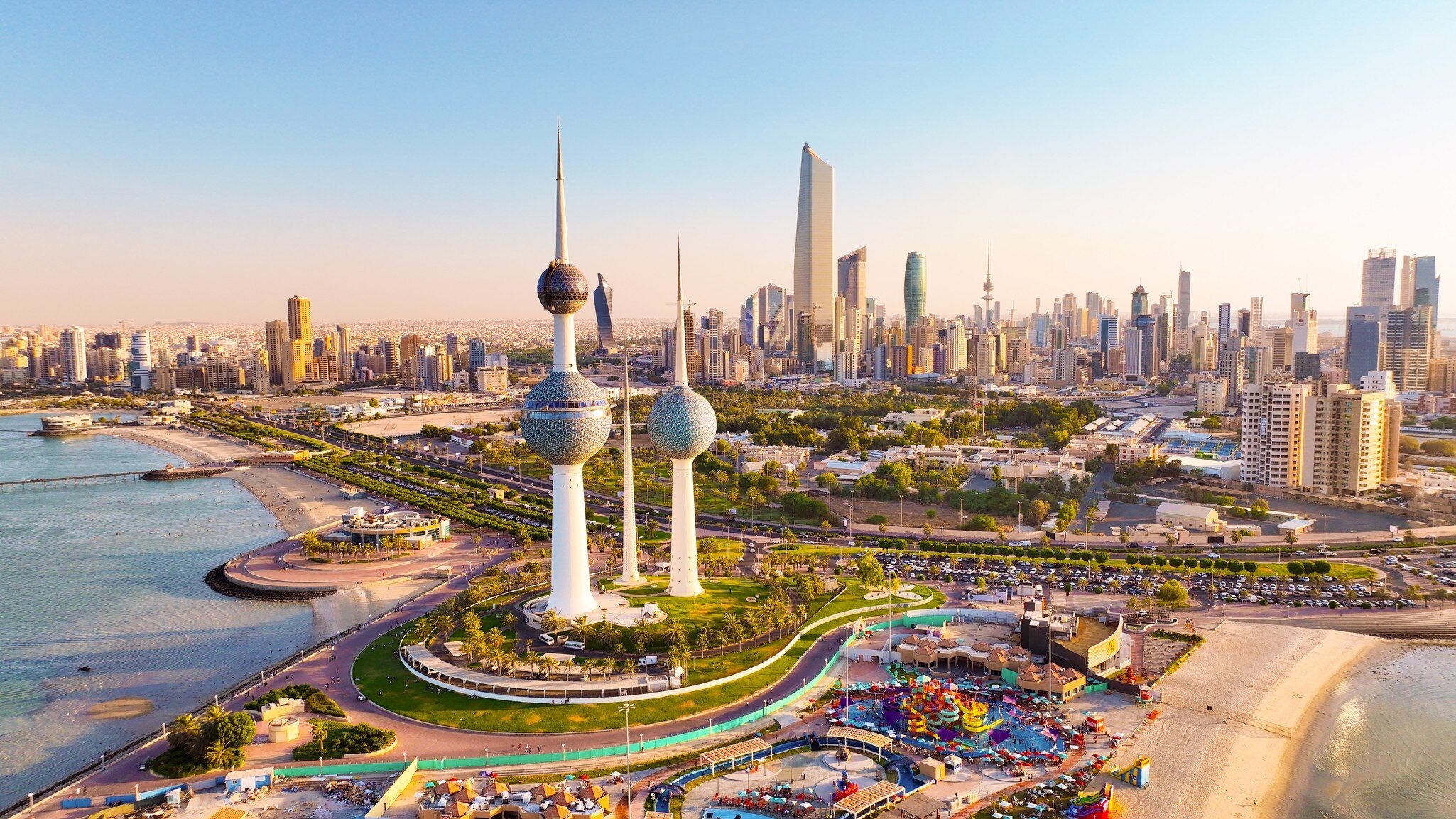 Aerial view of the Kuwait Towers on the waterfront with the Kuwait City skyline and Liberation Tower beyond