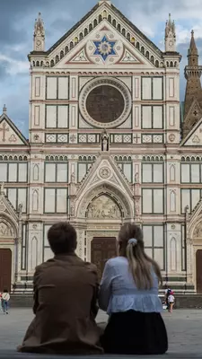 Florence, Italy - May 10 2025: Couple seen from behind looking at Basilica di Santa Croce in Florence under cloudy skies., License Type: media, Download Time: 2025-07-01T15:25:22.000Z, User: katelyn.perry_lonelyplanet, Editorial: true, purchase_order: 65050 - Digital Destinations and Articles, job: wip, client: wip, other: Katelyn Perry