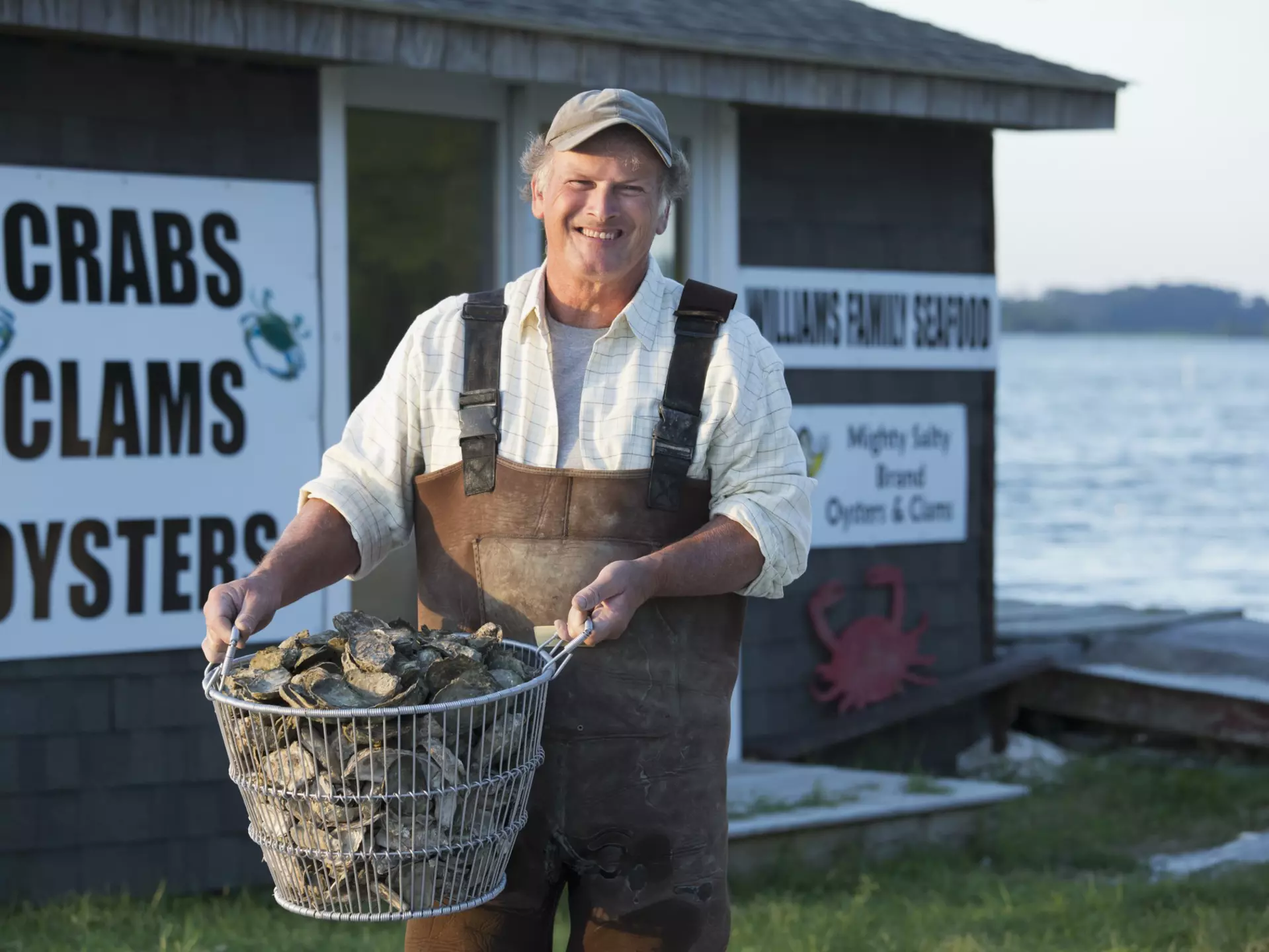 Caucasian fisherman holding basket of oysters in Northern Neck Virginia