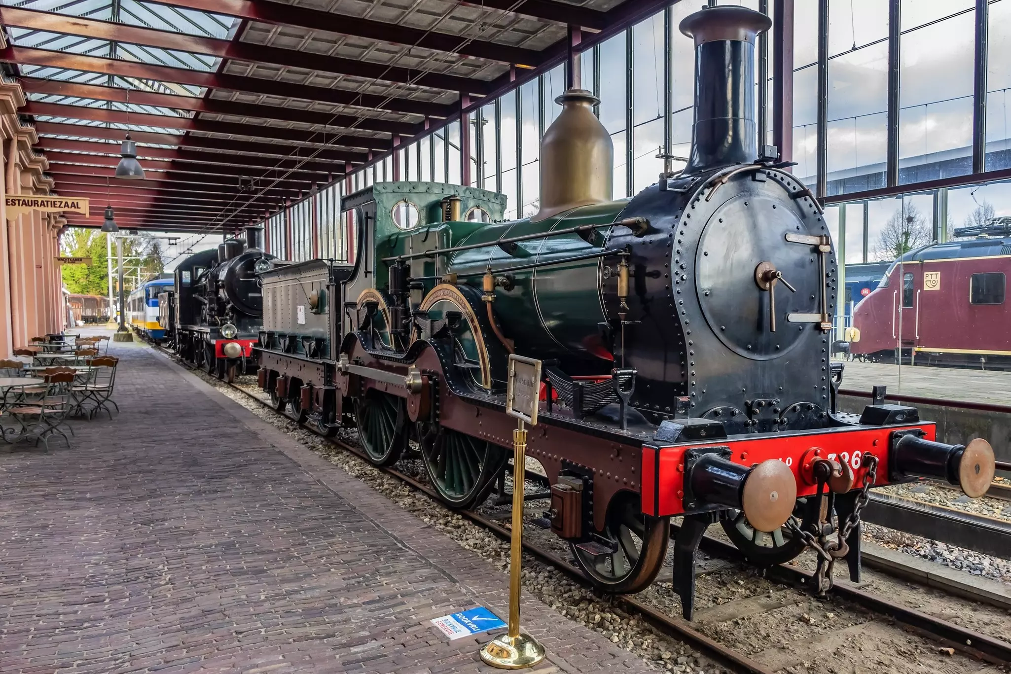 A vintage locomotive is on display in a covered pavilion at a railway museum.