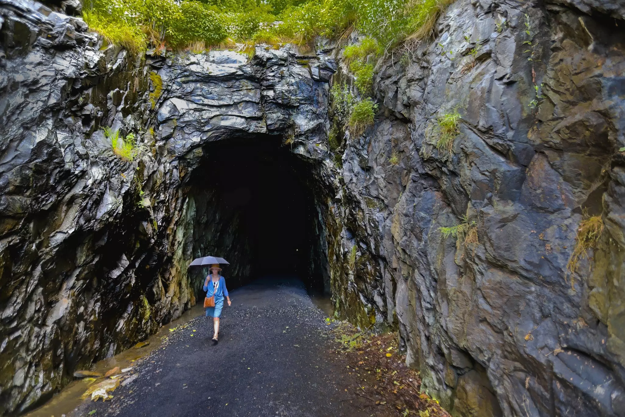 Woman With Umbrella exiting former railroad tunnel now the  Blue Ridge Tunnel East Trailhead.