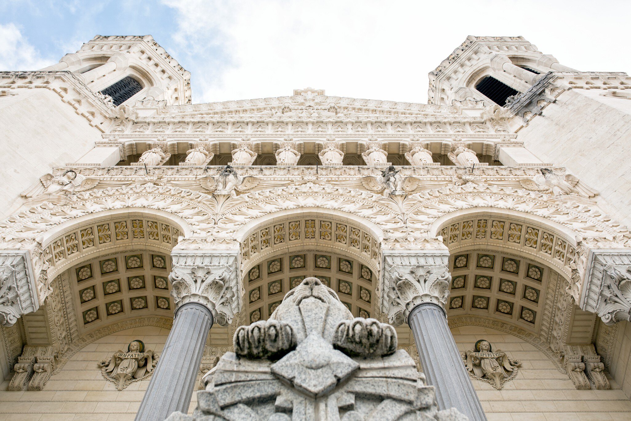 White stone facade of the Basilica of Notre-Dame de Fourvière in Lyon, France.