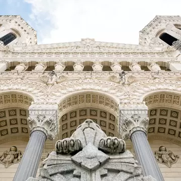White stone facade of the Basilica of Notre-Dame de Fourvière in Lyon, France.