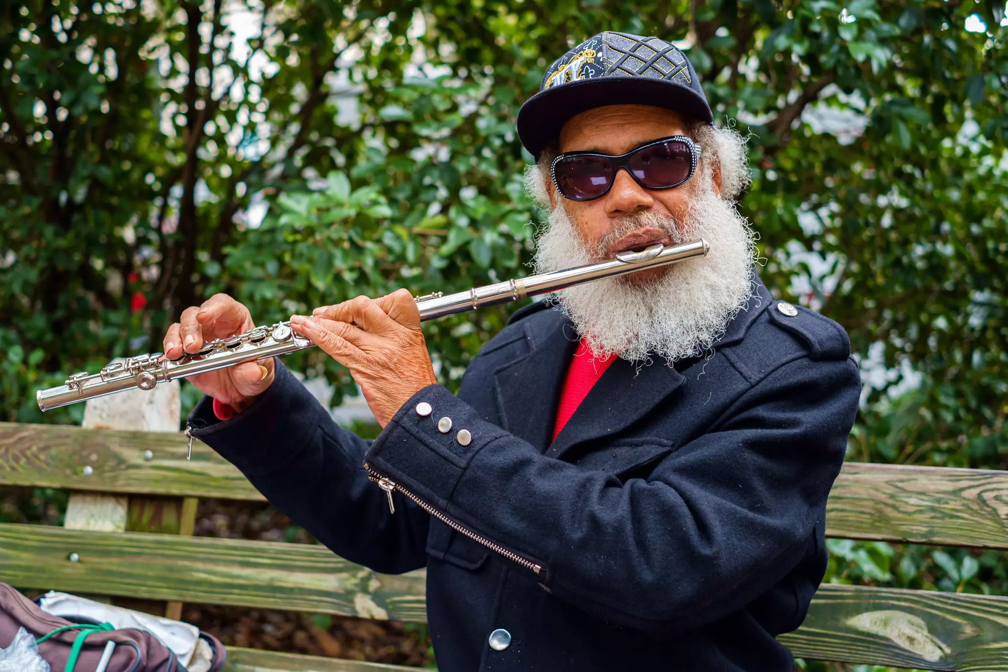 A musician plays the flute outside in a leafy square in Savannah's historic district