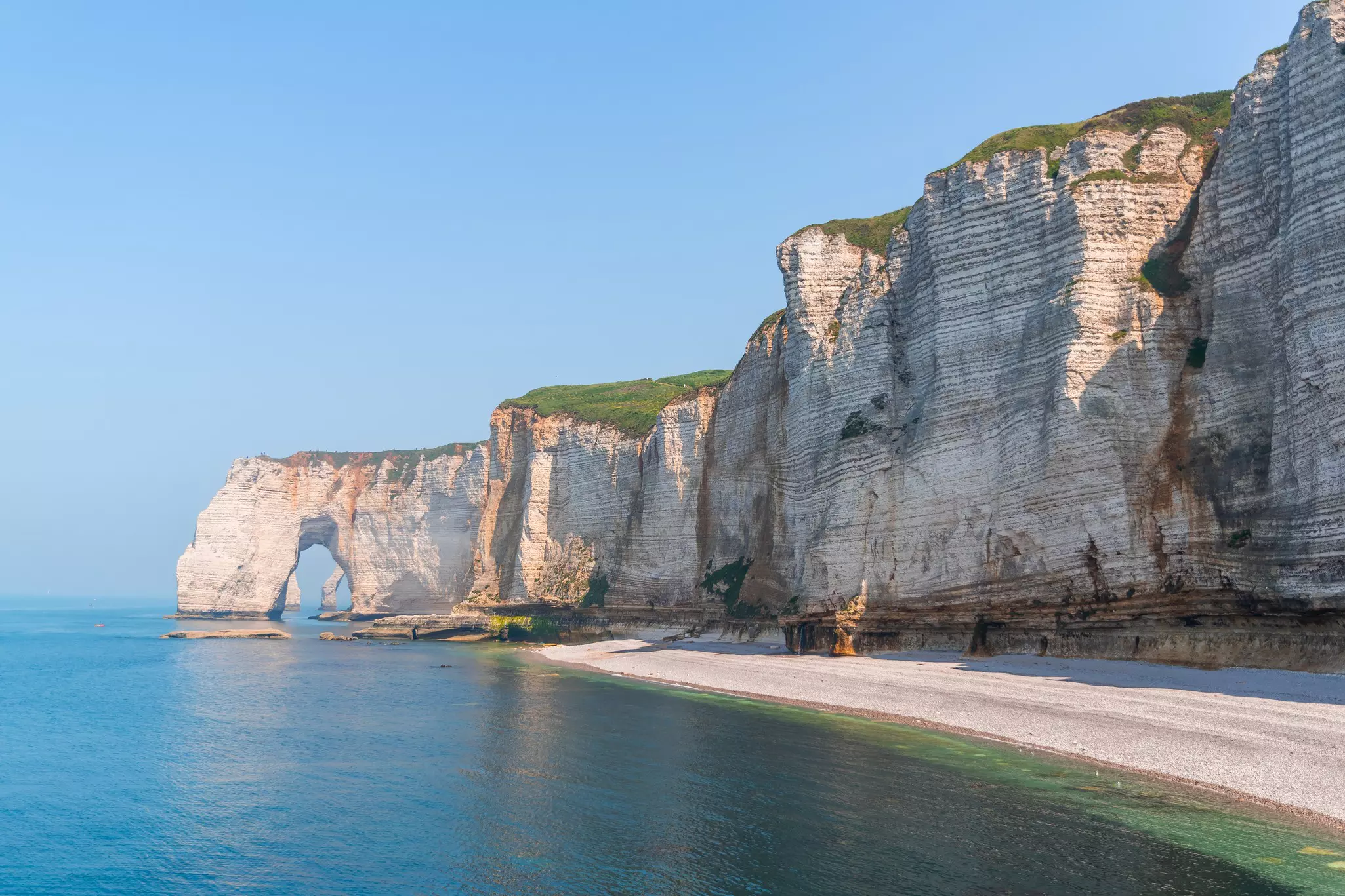 Chalk cliffs with a distinctive natural stone arch and sandy beach
