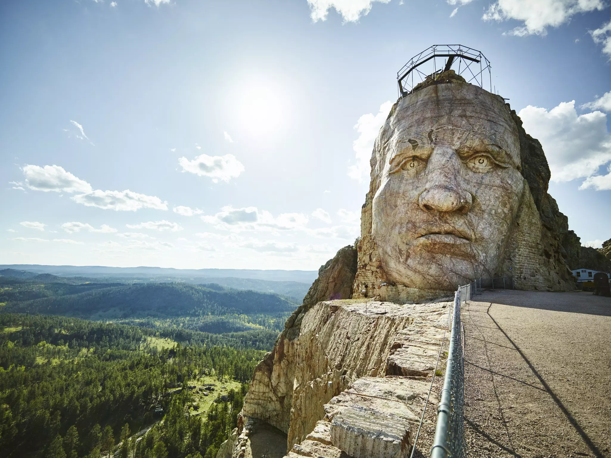 A huge stone sculpture of a head and face on a hill.