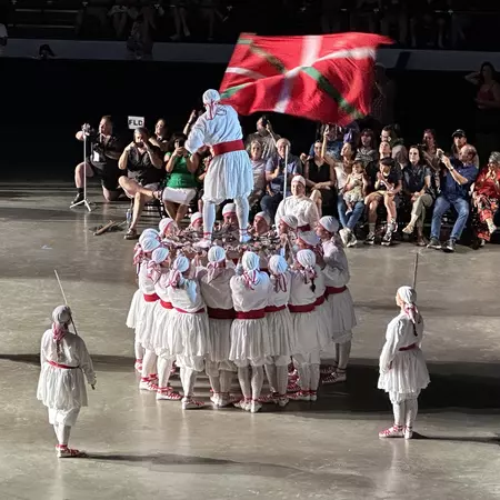 Dancers in white and red outfits using swords during a Festara dance