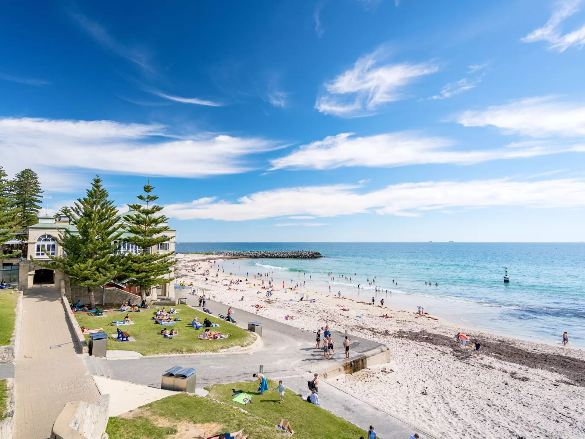 A sandy beach with people playing in the surf.