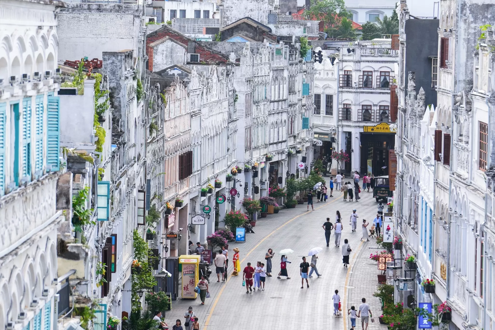A busy city street lined with neat rows of houses: Haikou in Hainan, China