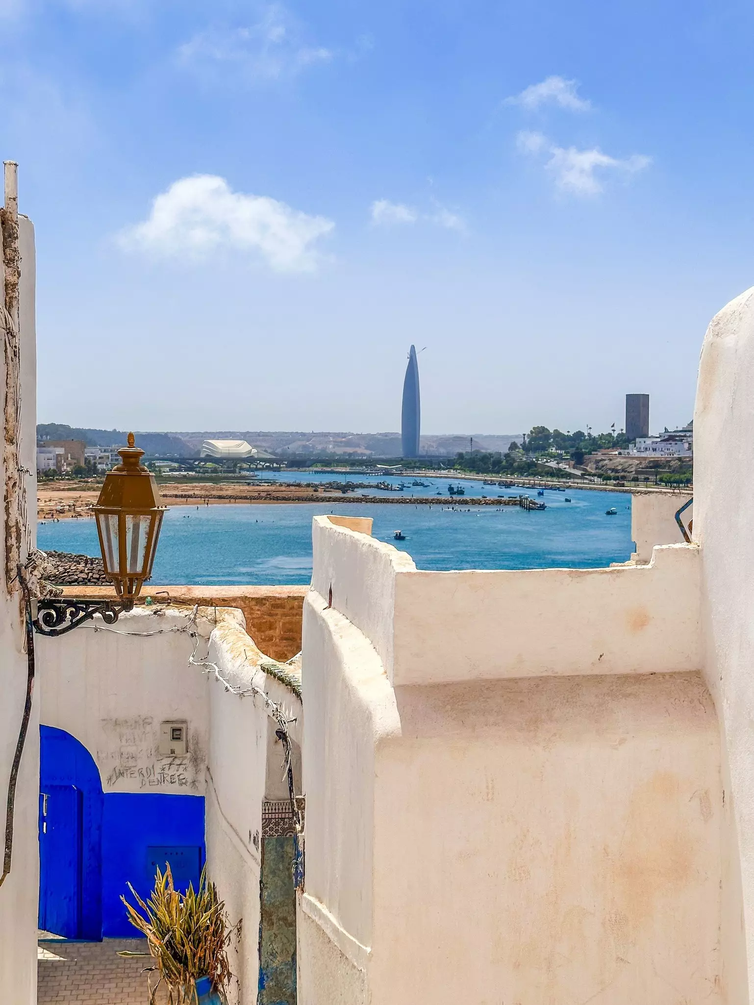 A viewpoint from an ancient walled town over a waterway towards modern high-rise buildings.