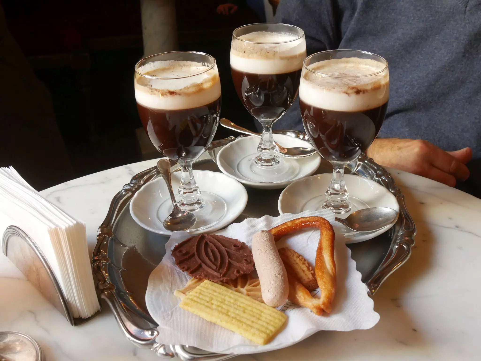 Bicerin, the typical drink of Turin, served in glass bowls on a silver tray with butter biscuits