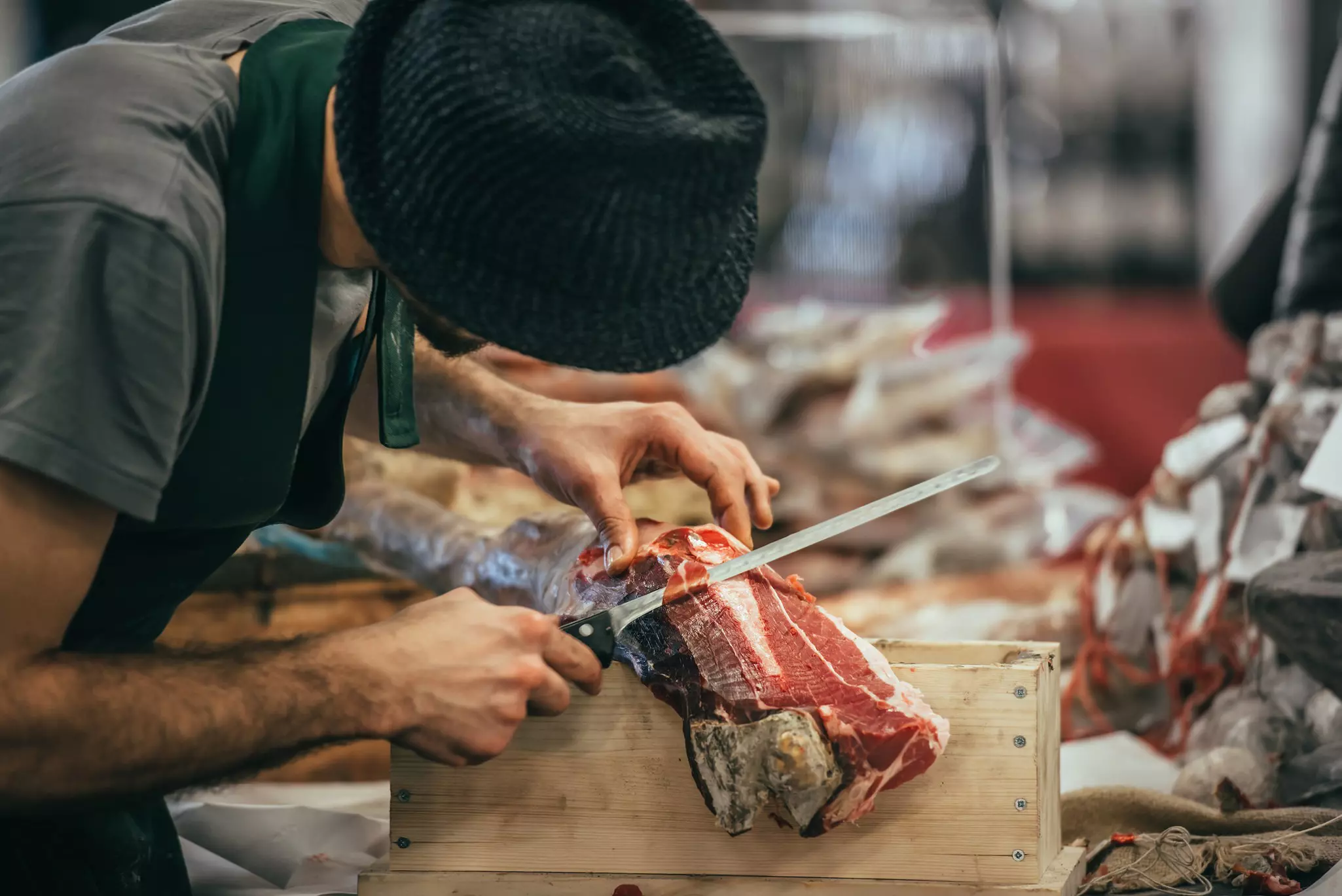 A man slicing dry-cured parma ham