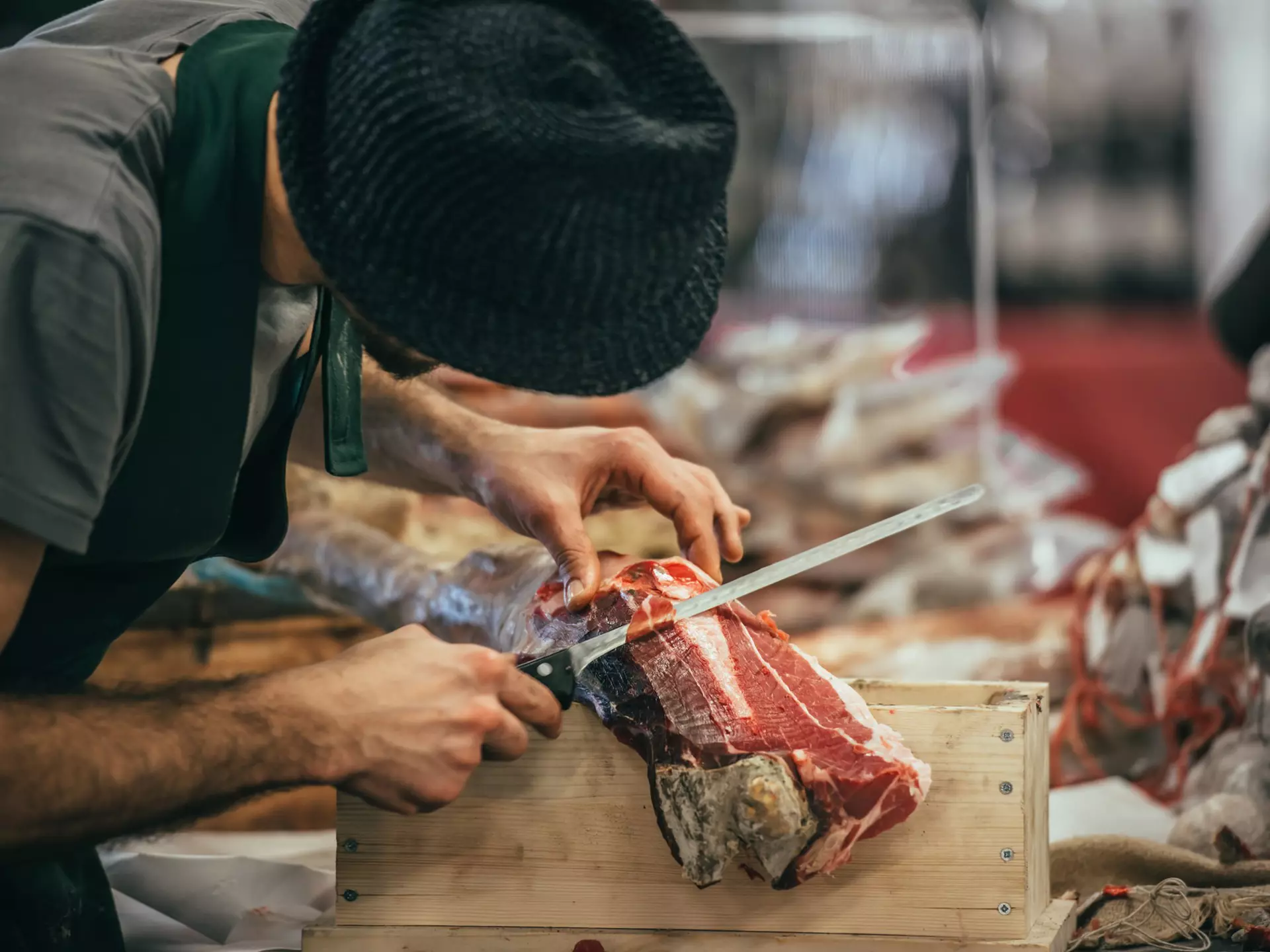 A man slicing dry-cured parma ham