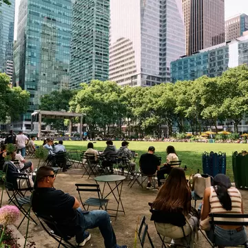 People reading, sitting, eatting and relaxing in Bryant Park, NYC, USA.