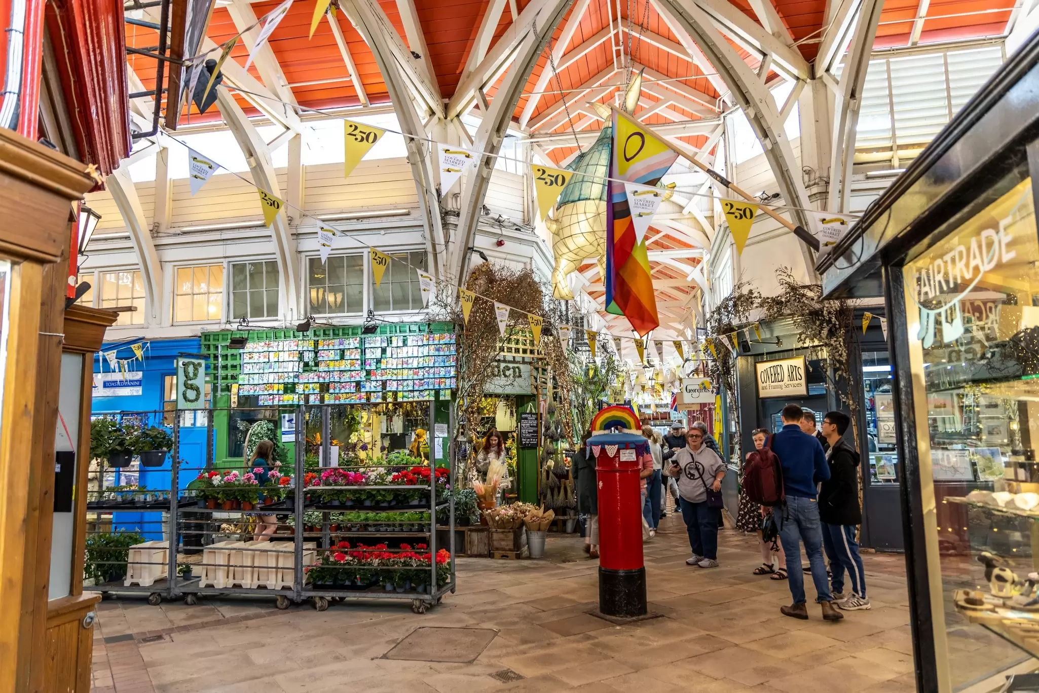 People walk around an indoor marketplace. 