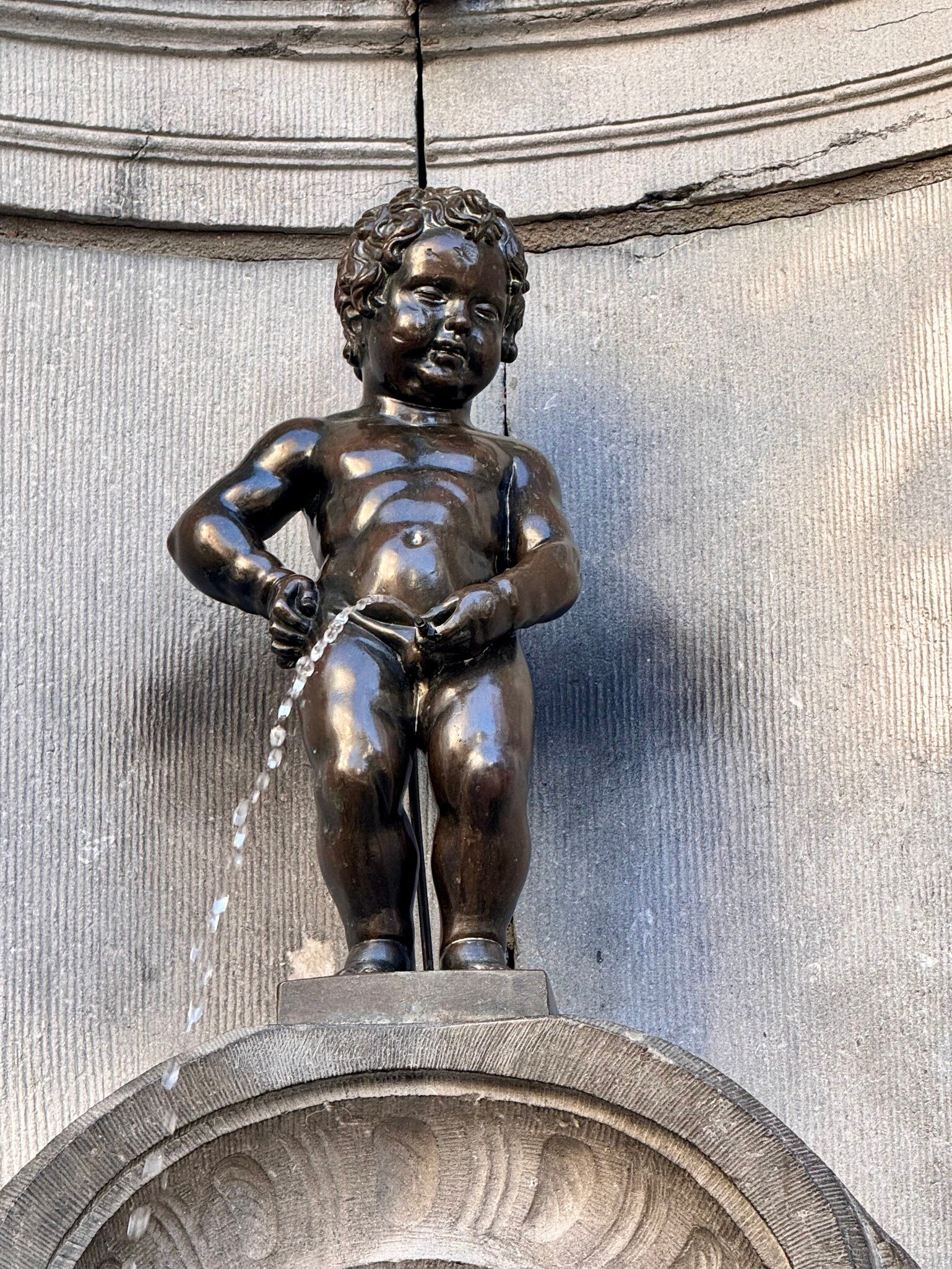 Brussels, Belgium - Mar 9, 2025: Manneken Pis (Little Pissing Man) is a landmark bronze fountain sculpture in central Brussels, Belgium., License Type: media, Download Time: 2026-04-24T13:56:22.000Z, User: LP_NZhan, Editorial: true, purchase_order: 65050 - Digital Destinations and Articles, job: App content, client: Lonely Planet App, other: Nadine Zhan