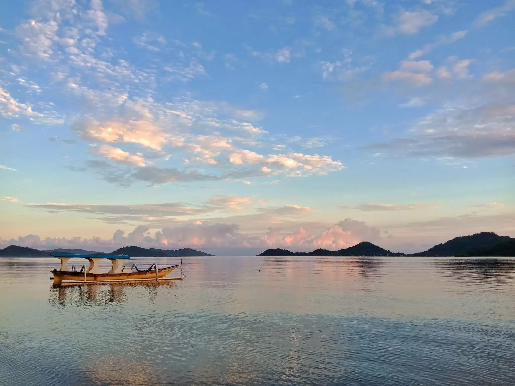 A fishing boat on calm water after sunset.