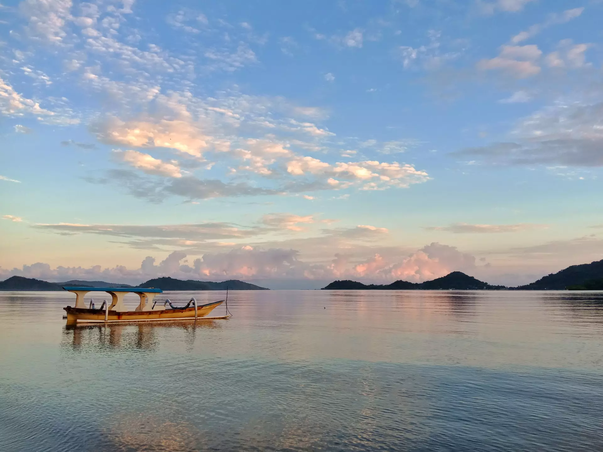 A fishing boat on calm water after sunset.