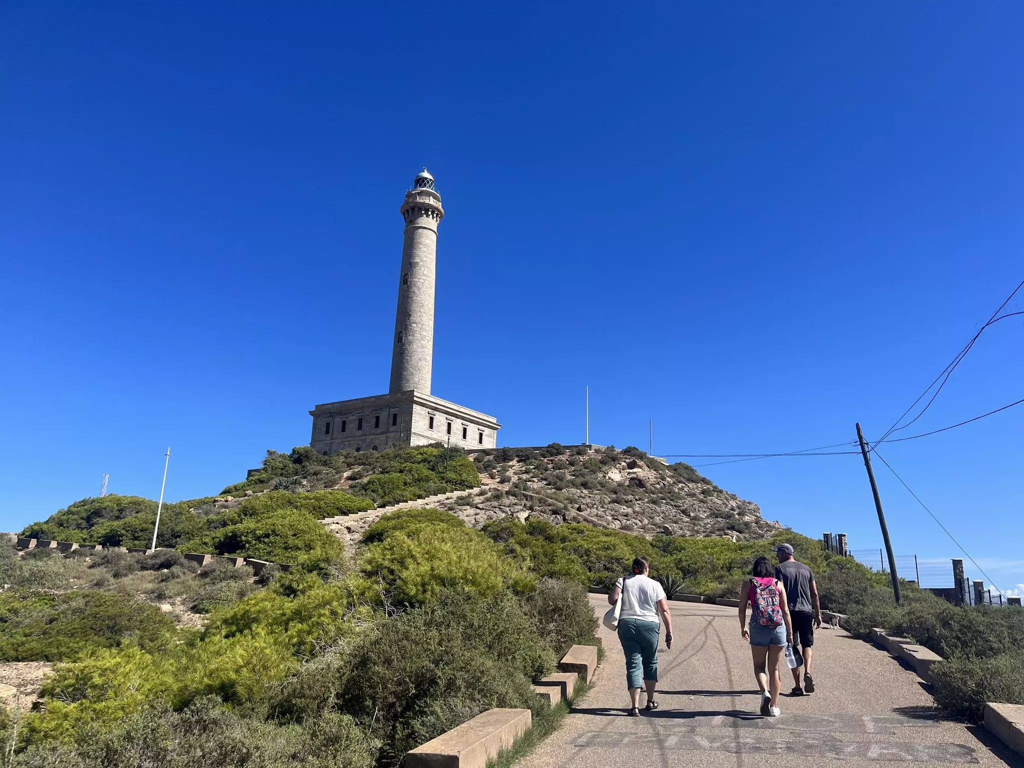 Walkers approaching the Cabo de Palos lighthouse in Murcia.