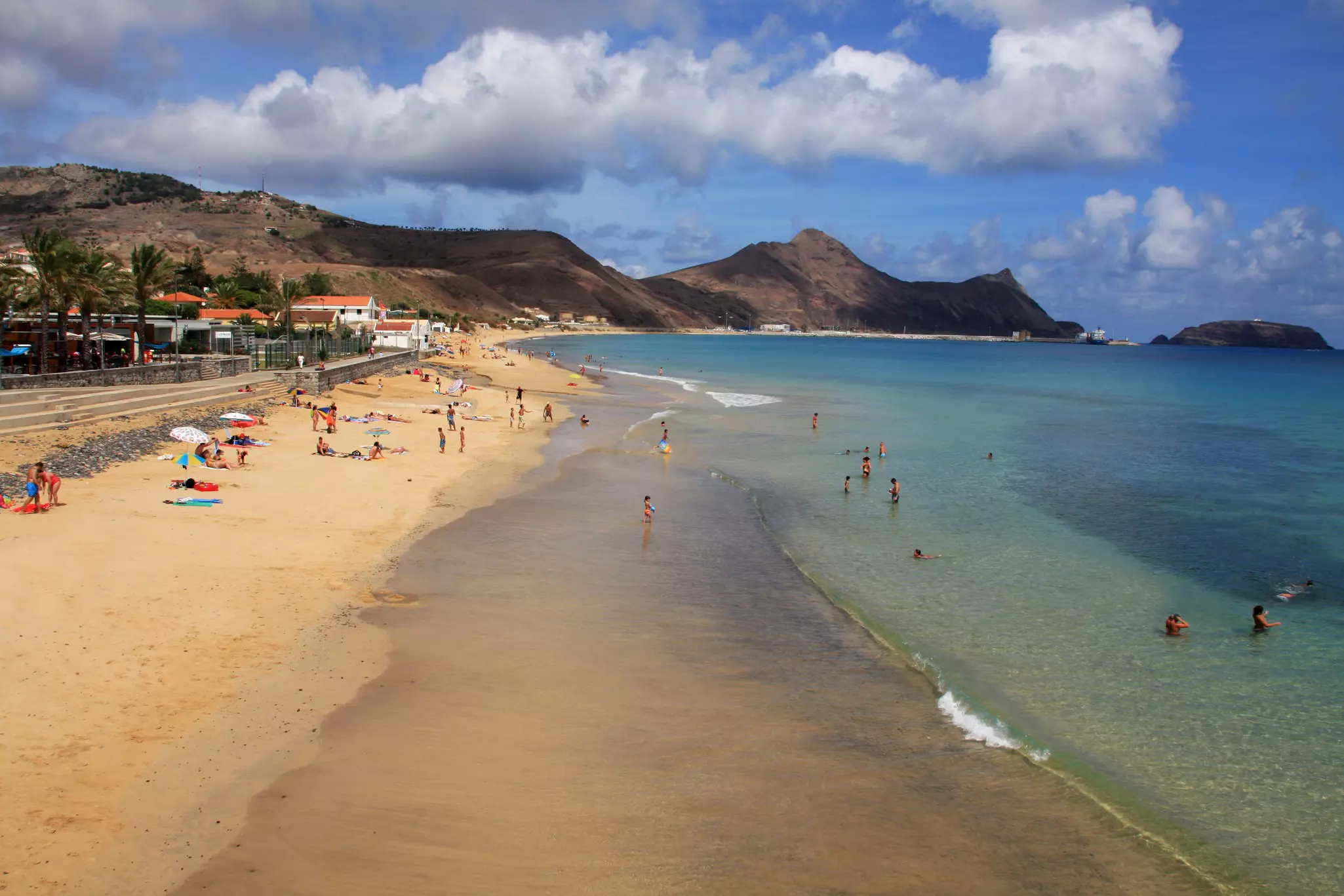 Porto Santo beach, Madeira Islands, Portugal is peppered with sunbathers and swimmers in its blue waters.