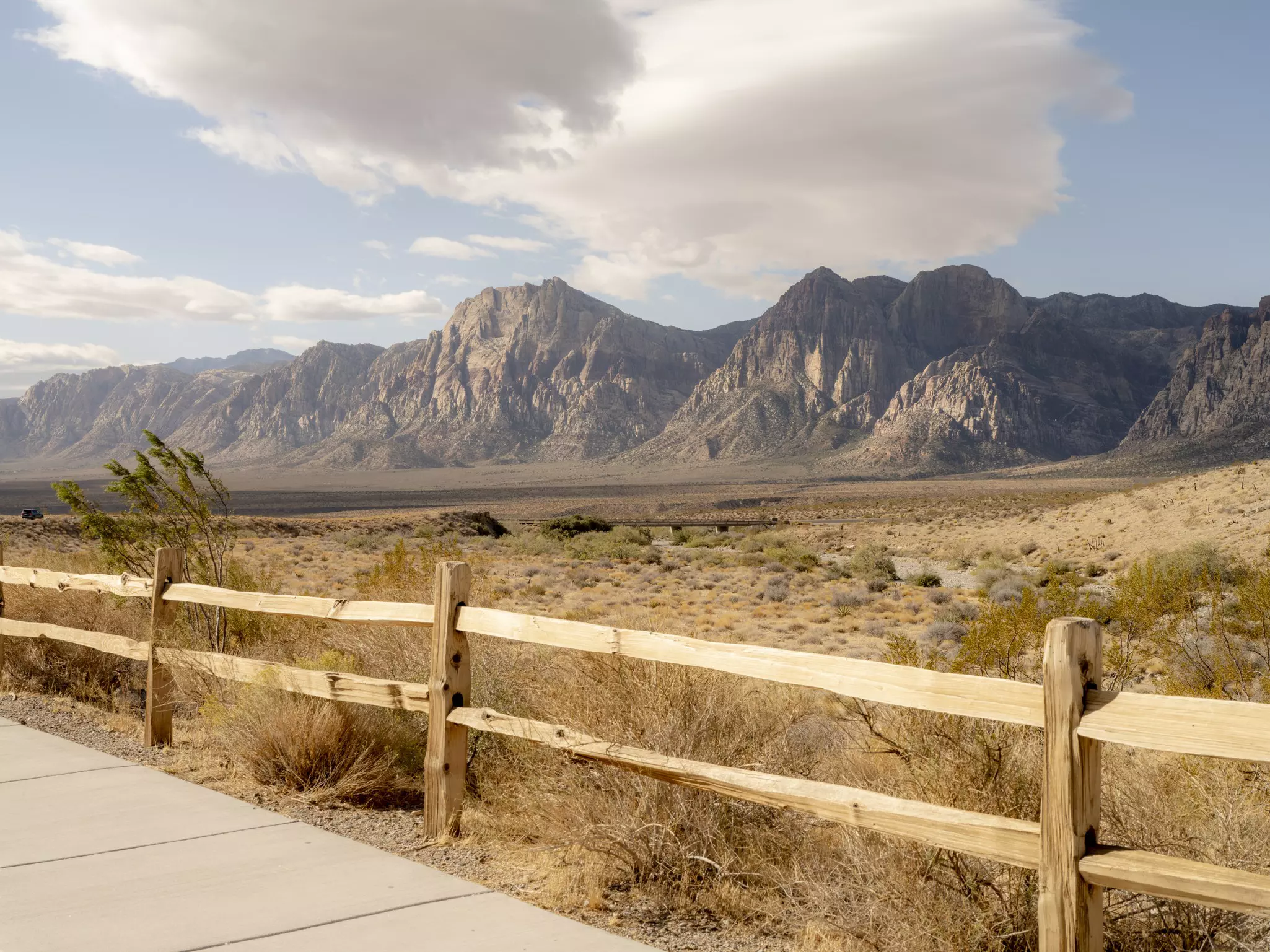 A wooden fence with rocky mountains behind it.