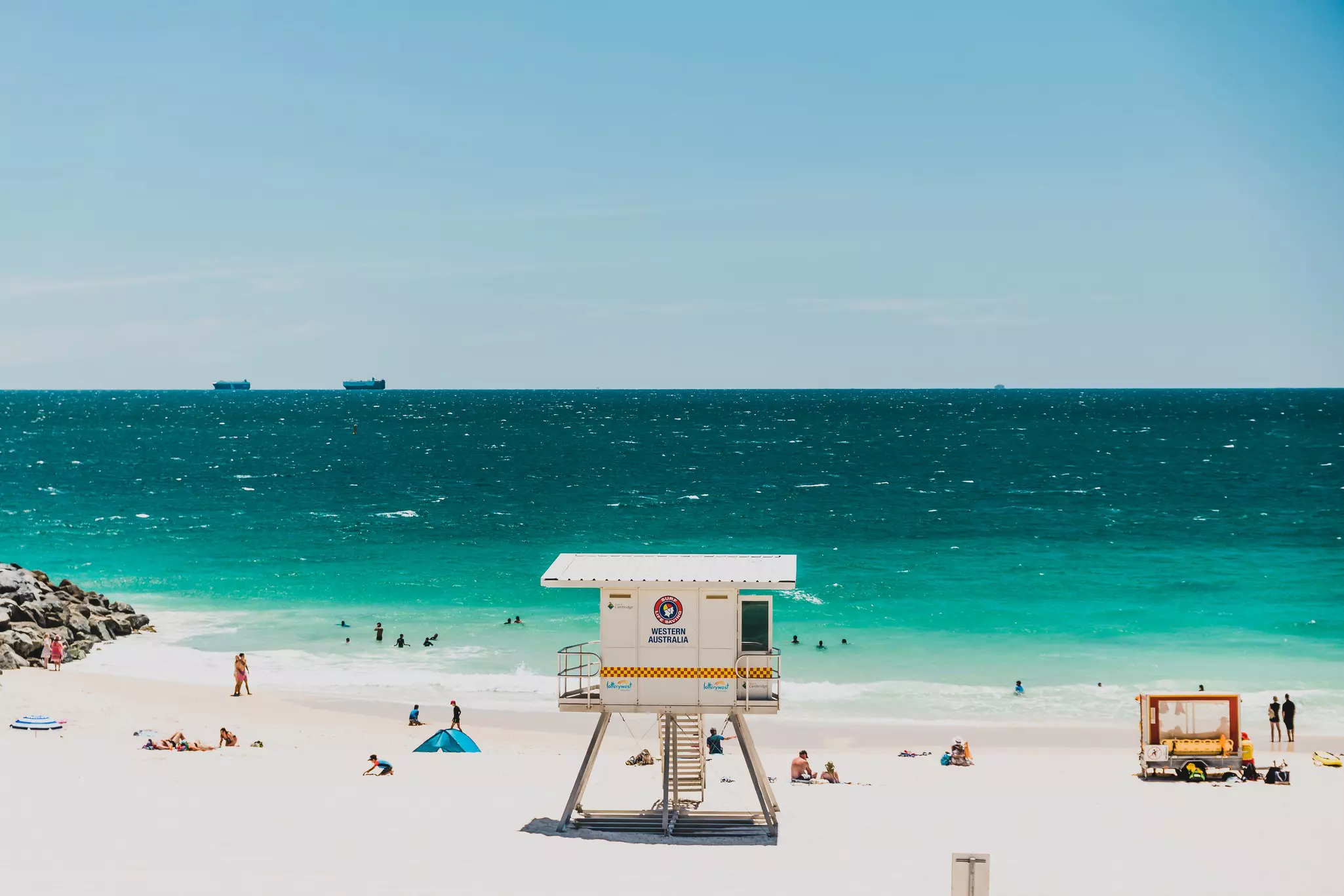 A lifeguard hut on a sandy beach facing the turquoise ocean.
