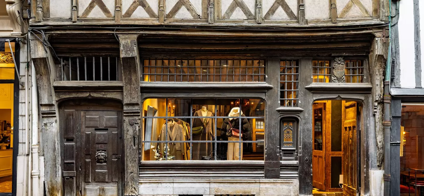 Historic storefront of a clothing store, in a medieval half-timbered house, located on a cobbled pedestrian street